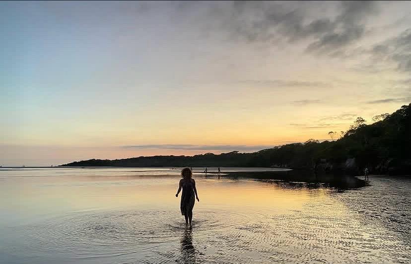 Pessoa caminhando na água ao entardecer