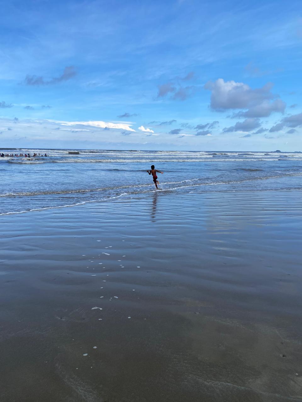 Pessoa correndo em direção às ondas do mar