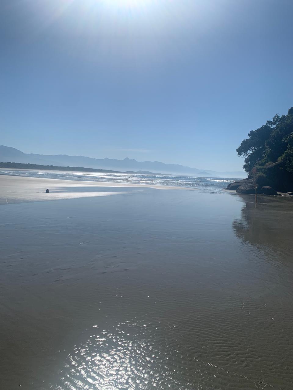 Luz do sol refletida na água rasa da praia